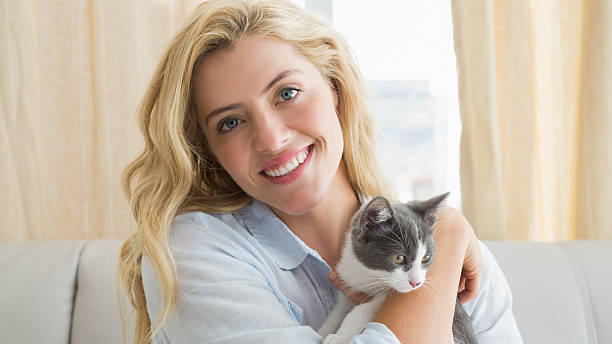 istock Pretty blonde with pet kitten on sofa 518355461