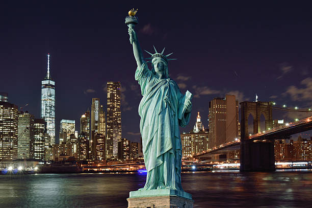 Horizonte de Manhattan à noite e a Estátua da Liberdade. - foto de acervo