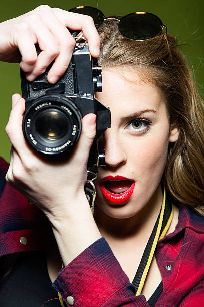 istock Pretty young woman taking photos with a retro camera. 518358962