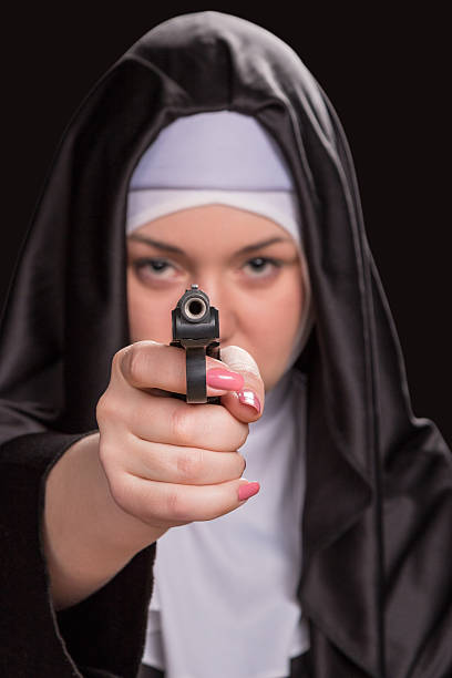 monja con un disparo de pistola - nun praying clergy women fotografías e imágenes de stock