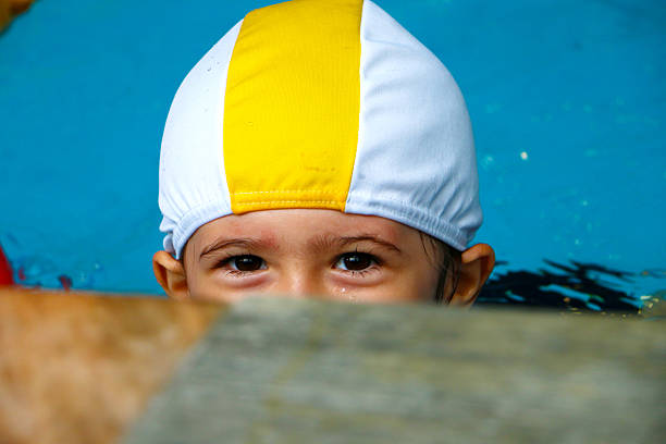 cheerful little baby girl with Downs Syndrome playing in the pool