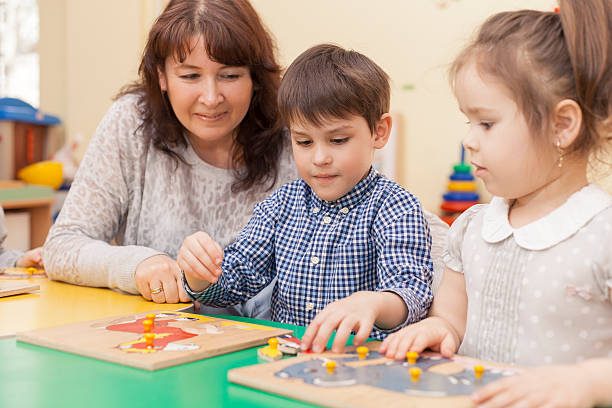 istock boy collects a puzzle at the table in the classroom 518366742