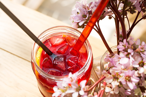 Hibiscus iced tea in a glass jar, close-up.