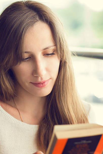 istock Young beautiful woman reading a book 518371048