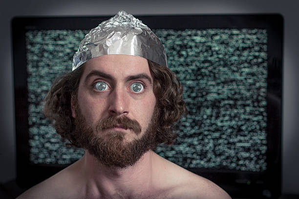 Television Hypnotized Brain washed crazy man is hypnotized by television program tin foil hat stock pictures, royalty-free photos & images