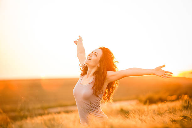 istock Woman enjoying sunset on wheat field 518376735