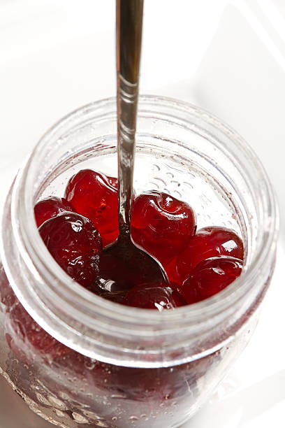 istock Glace cherries ingredients in a vintage jar on white 518379083