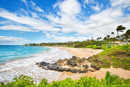 Resorts and vacation hotels lined the beach at the Wailea Beach on the southwest shore of the island of Maui in Hawaii. A beautiful sandy beach, a popular tourists destination in Hawaii. Photographed in horizontal format.