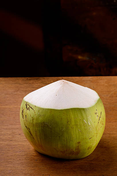 istock Green coconut on wooden table. 518379917