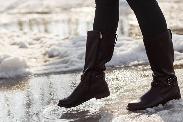 istock girls legs in boots trying to go on spring puddle 518381054