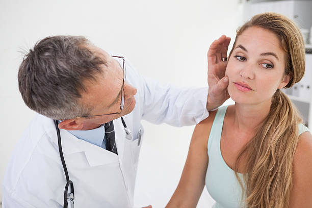 istock Doctor examining patients face 518381671