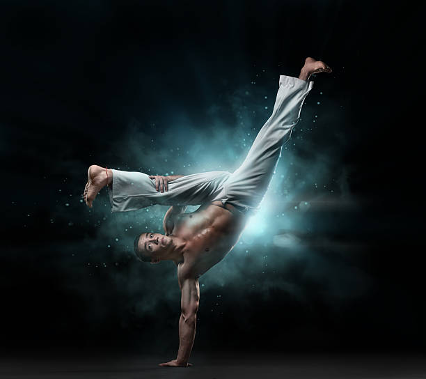 istock combative sport: male fighter trains capoeira 518382992