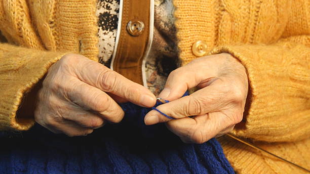 старая женщина сидит дома и вязаные изделия одежды - grandmother knitting senior women senior adult стоковые фото и изображения