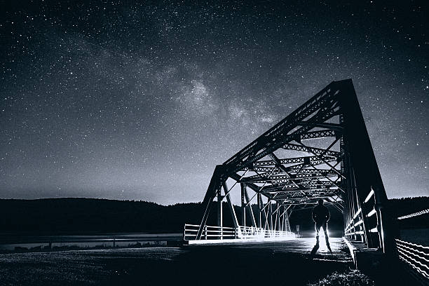 Man stargazing on the bridge