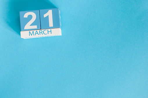 March 21st. Image of march 21 wooden color calendar on blue background.  Spring day, empty space for text. World Down Syndrome Day, International DAy Of Forests.