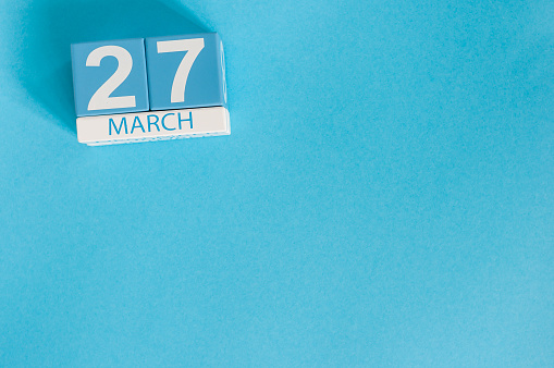 March 27th. Image of march 27 wooden color calendar on blue background.  Spring day, empty space for text. World Theatre Day.