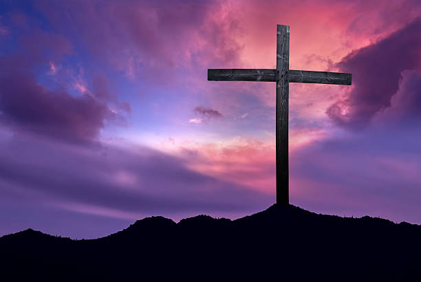istock Christian cross over dark sunset background 518394778