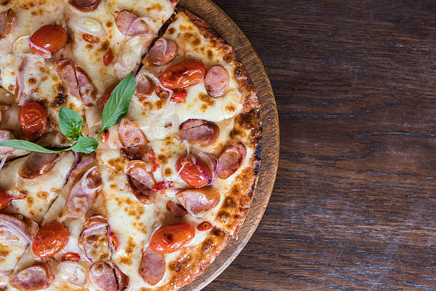 istock spicy sausage pizza on wooden table, Top view 518397164