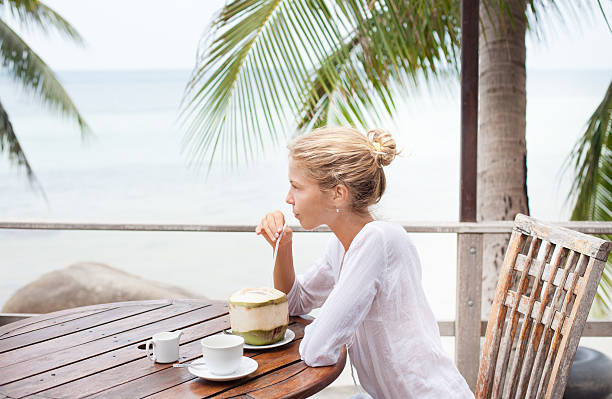 istock Young woman enjoys drinking coffee and coconut 518397258