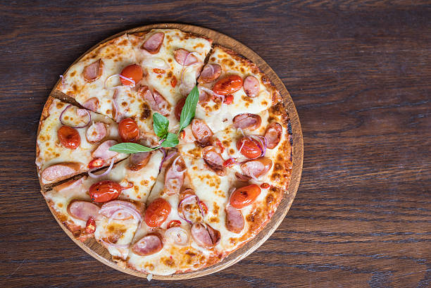 istock spicy sausage pizza on wooden table, Top view 518397276