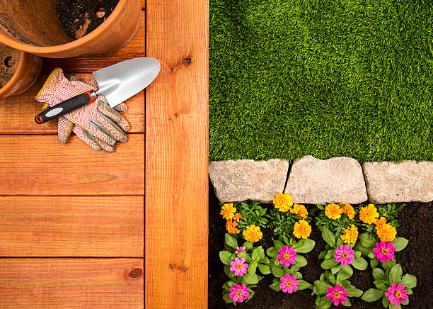 Spring Gardening A aerial view of a red wood deck with clay flower pots, work gloves, and spade.  The aerial shot alto shows the perfectly cut yard with stone pavers and flower bed.  Please see my portfolio for other gardening related images.  deck stock pictures, royalty-free photos & images