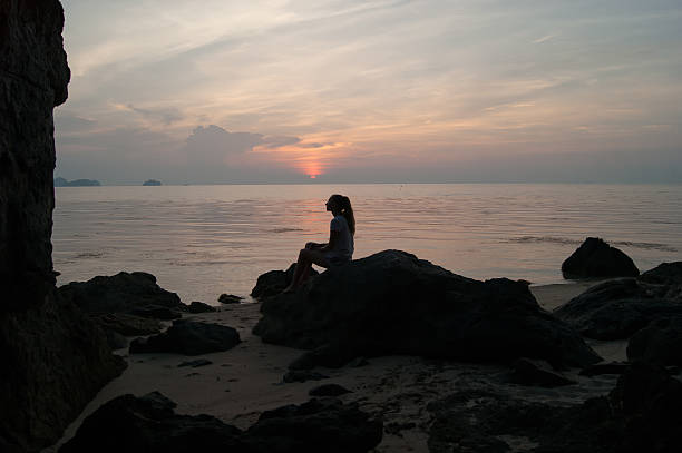istock The girl at sunset standing on the seashore 518399694