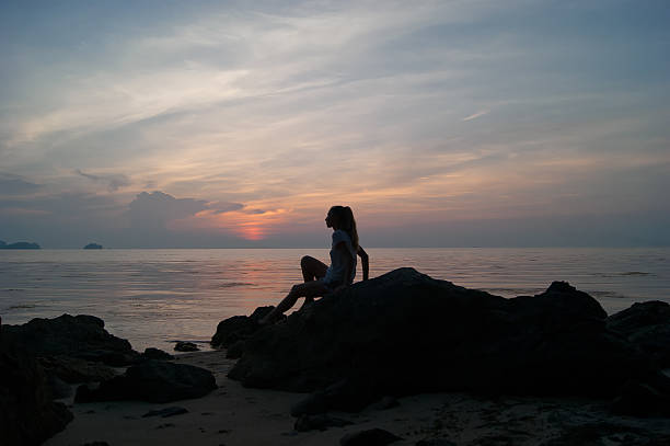 istock The girl at sunset standing on the seashore 518399722