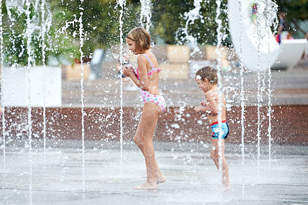 istock Happy children playing in a fountain 518400489