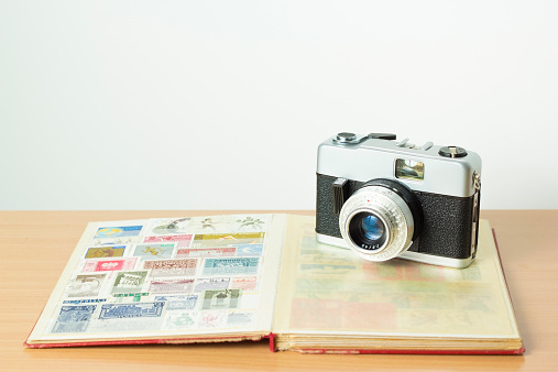 Vintage 35mm film camera on top of a stamp collection book