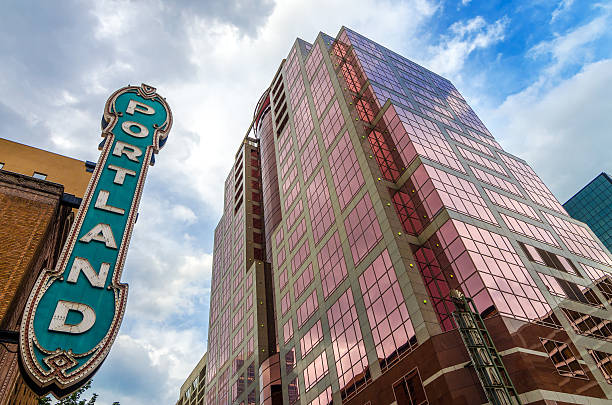 Iconic Portland Sign Iconic Portland sign with pink skyscraper rising next to it portland oregon photos stock pictures, royalty-free photos & images