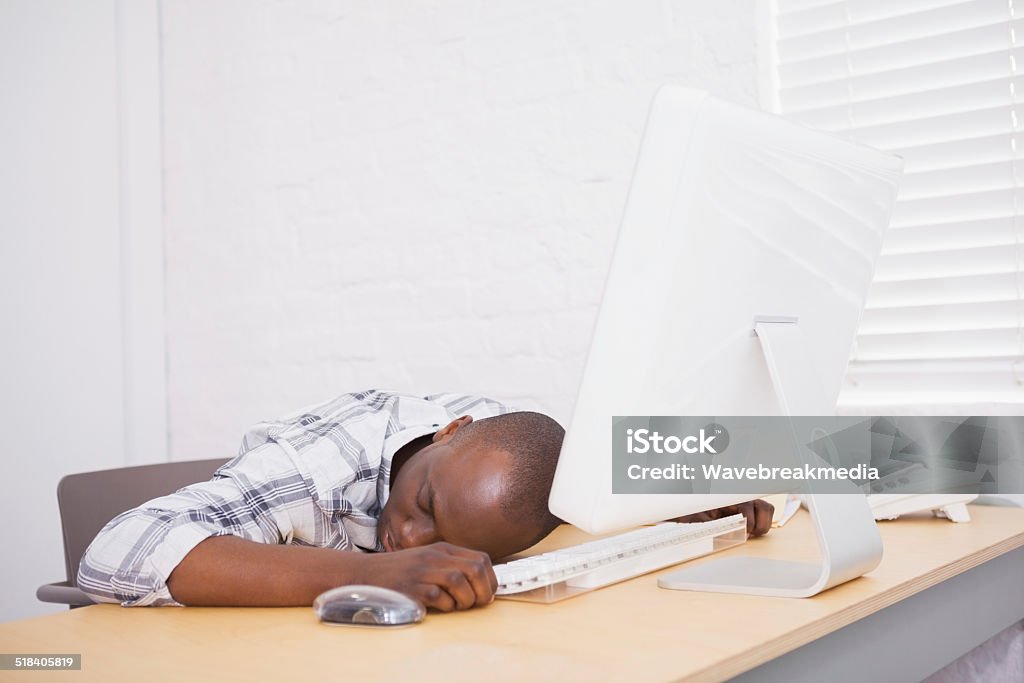 Casual businessman sleeping at his desk Casual businessman sleeping at his desk in the office 20-24 Years Stock Photo