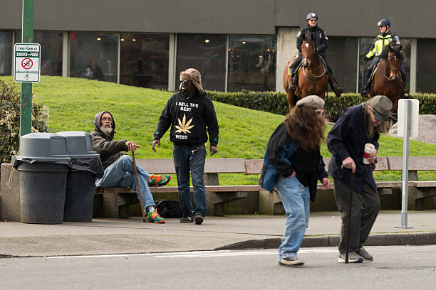 Victor Steinbrueck Park Seattle, USA - March 24, 2016: A man wearing a shirt that reads I SELL THE BEST WEED in the Victor Steinbrueck Park with tow police officers on horseback late in the day across from the famous Pike Place Market. The city of Seattle is one of the early states to legalize Marijuana. german social democratic party photos stock pictures, royalty-free photos & images