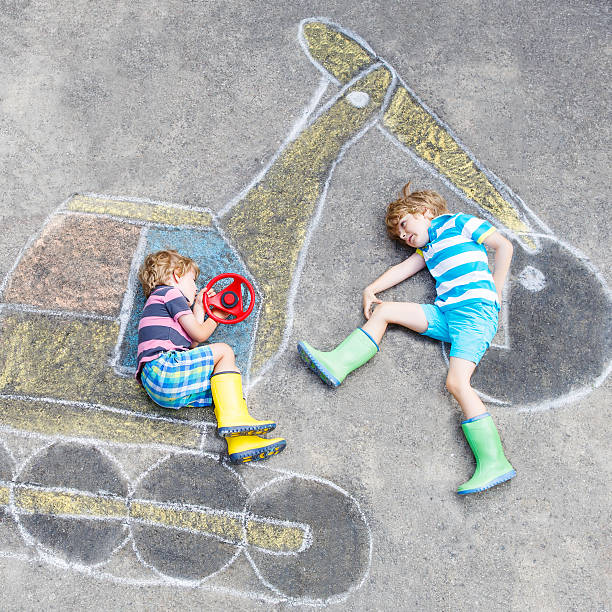 istock Two little kid boys with excavator chalk picture 518409128