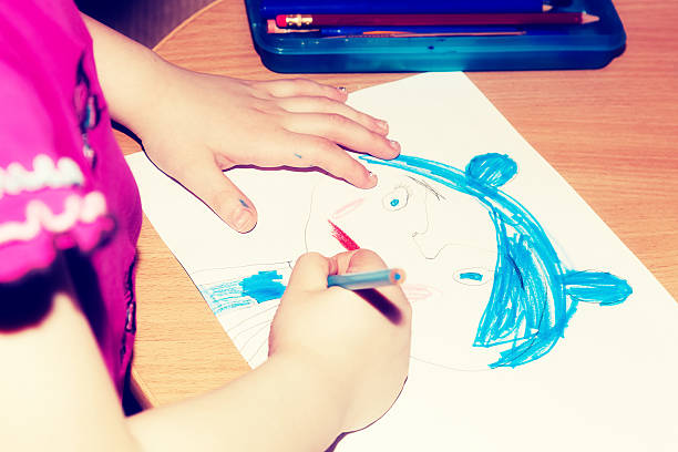 istock Child's hands drawing a picture on paper 518410328