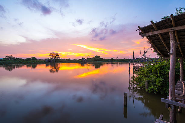 istock Part of shack near river in sunset. 518411468