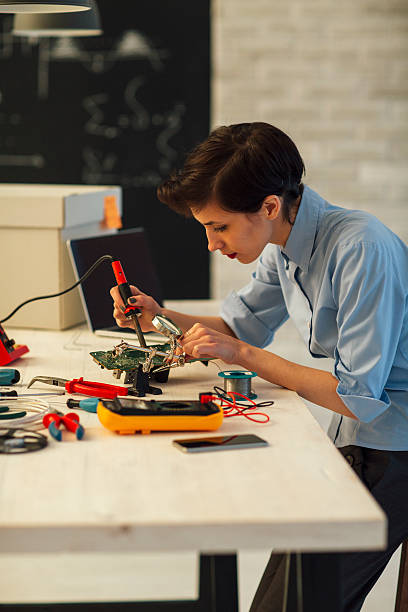 istock Woman Soldering a circuit board in her office. 518412940