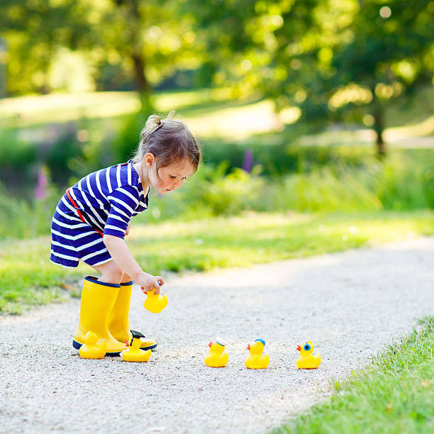 istock Little girl playing in forest and wearing boots 518422914