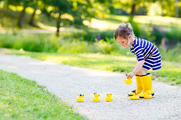 istock Little girl playing in forest and wearing boots 518423824