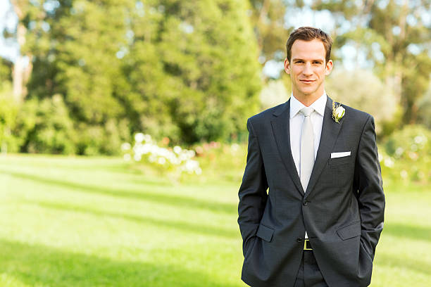 istock Groom Standing With Hands In Pockets In Garden 518425243