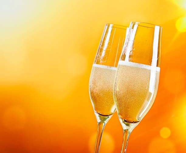 istock champagne flutes with golden bubbles 518427234