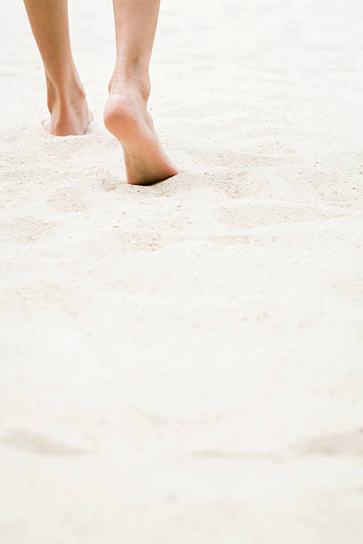 istock Woman's legs walking in the sand 518427490