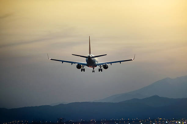 istock The passenger plane which flies in the nightfall sky 518429582