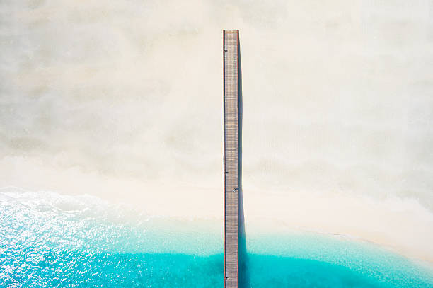 top view jetty lagoon broad sandy beach amazing aerial view broad white sandy beach wooden jetty and lagoon jetty aerial stock pictures, royalty-free photos & images