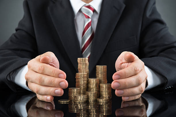 istock Businessman Saving Pile Of Coins 518433384