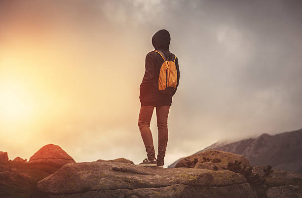 istock Traveler with backpack walking in mountains at sunset 518434954