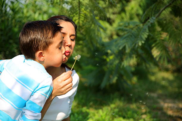 istock Mother and son blowing dandelion 518435550