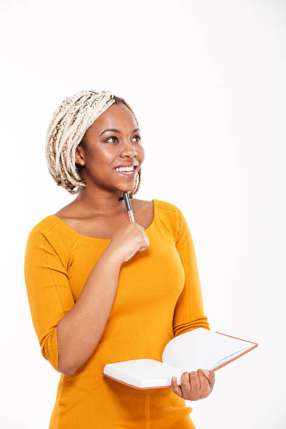 istock Happy african american woman smiling and writing in notebook 518437462
