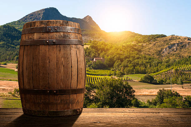 istock corkscrew and wooden barrel, vineyard on background 518437544