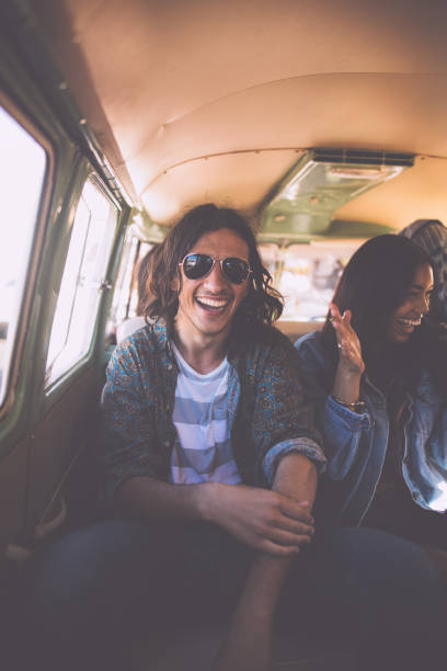 istock Young hipster couple laughing in a van on road trip 518437668
