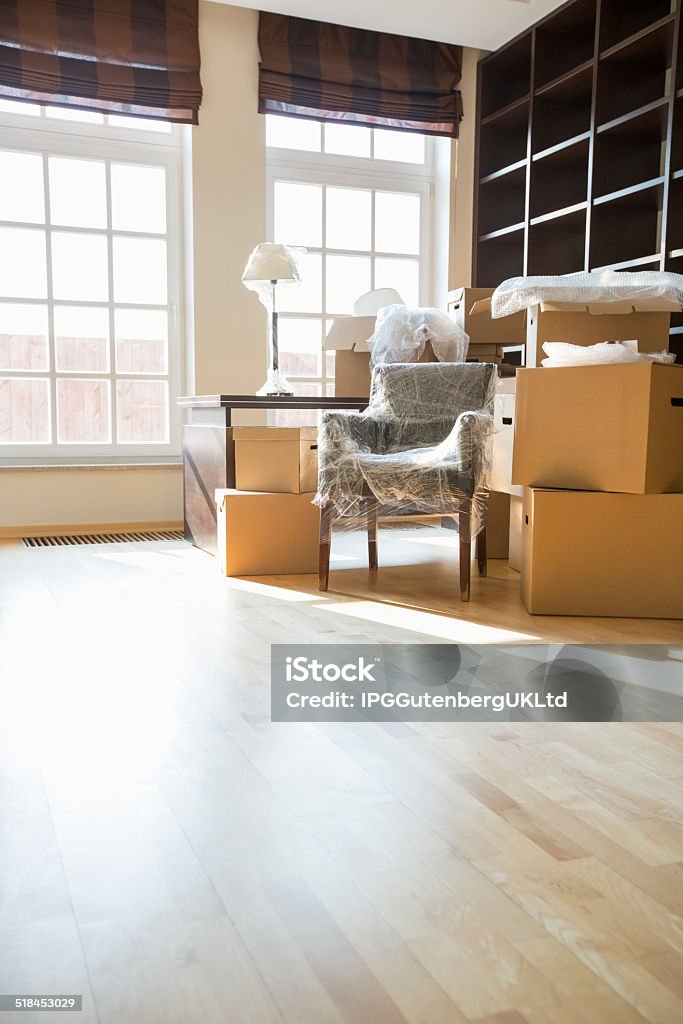 Moving home Cardboard boxes and furniture in new home Moving House Stock Photo